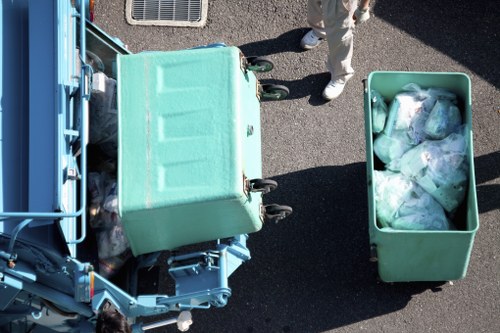 Operative wearing PPE loading green waste onto a vehicle